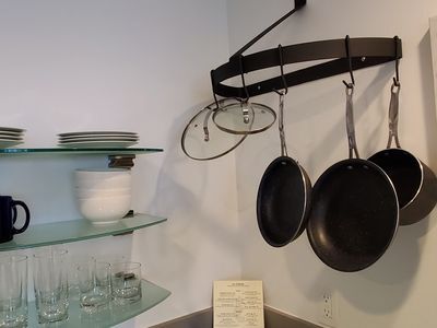 A kitchen with pots and pans hanging from the ceiling.